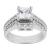 A silver engagement ring features a large princess-cut center stone surrounded by smaller stones on both sides.