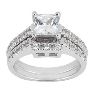 A silver engagement ring features a large princess-cut center stone surrounded by smaller stones on both sides.