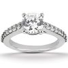A silver engagement ring features a large round diamond surrounded by smaller stones along the band.