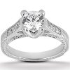 A silver engagement ring features a large, round diamond surrounded by smaller stones on a decorative band.