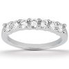 A silver band ring featuring a line of six round, clear gemstones set in a row.