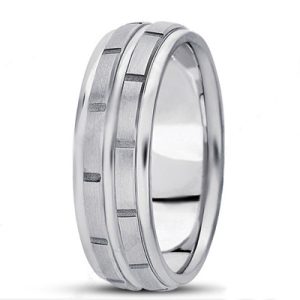 A silver wedding band with a brushed finish and decorative grooves.