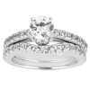 A silver engagement ring set features a large round diamond centered between two bands adorned with smaller diamonds.