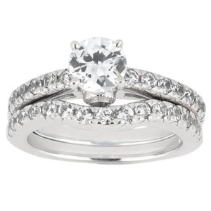 A silver engagement ring set features a large round diamond centered between two bands adorned with smaller diamonds.