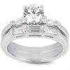 A silver engagement ring features a large round diamond center stone flanked by two rows of rectangular diamonds.