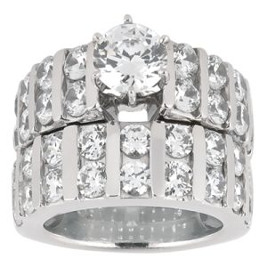 An engagement ring with a large central diamond surrounded by smaller diamonds set in a silver band.
