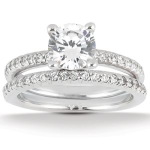A silver engagement ring with a central round diamond surrounded by smaller diamonds on two bands.