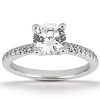 A close-up view of a silver engagement ring featuring a large round diamond centerpiece surrounded by smaller diamonds on the band.