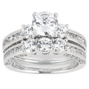 A multi-stone engagement ring featuring a central round diamond surrounded by smaller diamonds on a silver band.