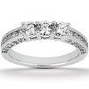 Three-stone diamond ring with a silver band featuring a row of smaller diamonds along the sides.