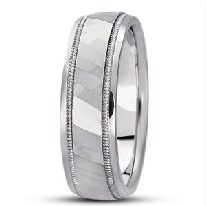 A silver wedding band with a textured surface and decorative grooves along the edges.