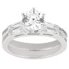 A silver engagement ring featuring a large round diamond at the center flanked by smaller rectangular diamonds.
