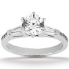 A silver engagement ring featuring a round center diamond and two elongated side stones.