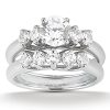 A diamond engagement ring set featuring a central round stone and smaller diamonds arranged in a stacked design.