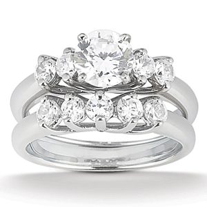 A diamond engagement ring set featuring a central round stone and smaller diamonds arranged in a stacked design.