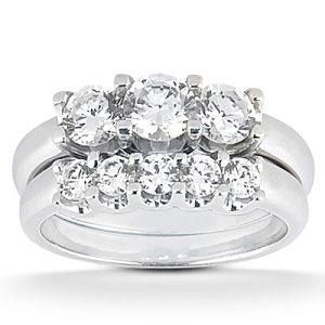 A silver engagement ring features a cluster of round, clear diamonds arranged prominently on the band.