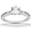 A silver engagement ring features a large round diamond in the center with smaller diamonds set on the band.