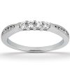 A silver ring with a row of five clear gemstones set in the center and smaller gemstones on either side.