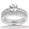 A diamond engagement ring set features a central round diamond surrounded by smaller stones on a silver band.