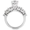 A silver ring features a large central diamond surrounded by smaller gemstones on either side.