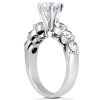 A silver ring featuring a large central diamond and several smaller stones arranged along the band.
