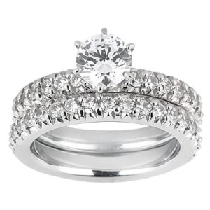 A diamond engagement ring set features a central round diamond surrounded by smaller diamonds on a white metal band.