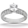 A silver engagement ring features a large central diamond surrounded by smaller diamonds along the band.