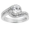 A silver engagement ring with a large round diamond and smaller diamonds set in a wavy band design.