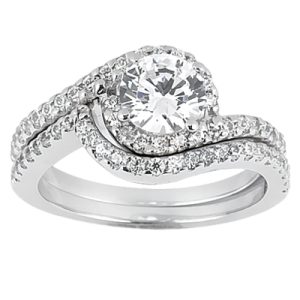 A silver engagement ring with a large round diamond and smaller diamonds set in a wavy band design.