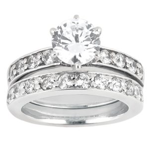 A silver engagement ring with a large central diamond surrounded by smaller diamonds on two bands.
