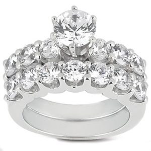 A shiny silver ring adorned with a central large diamond and multiple smaller diamonds surrounding it.
