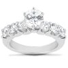 A silver engagement ring features a large central diamond surrounded by smaller diamonds on either side.