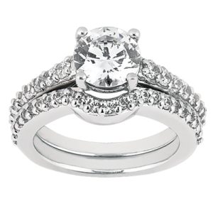 A diamond engagement ring with a large central stone and smaller accent stones on a silver band is displayed against a white background.