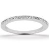A silver ring with a row of small, clear gemstones along the top edge rests on a flat surface.