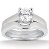 A diamond engagement ring with a round center stone and a sleek, polished band.