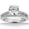 A silver engagement ring featuring a large round diamond center stone flanked by smaller diamonds on the band.