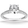 A silver engagement ring features a large round diamond at the center with smaller stones set along the band.