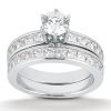 A silver wedding ring set features a central round diamond and smaller diamonds along the bands.