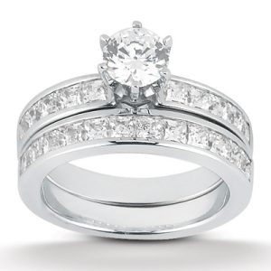 A silver wedding ring set features a central round diamond and smaller diamonds along the bands.
