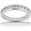 A silver band ring with a row of evenly set clear gemstones along its outer edge rests on a light surface.