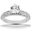 A silver engagement ring features a large central round diamond surrounded by smaller diamonds on the band.
