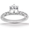 A silver engagement ring features a large round diamond surrounded by smaller accent stones.