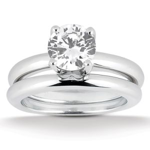 A silver two-piece engagement ring set featuring a round, sparkling diamond as the central stone.