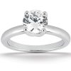A solitaire engagement ring features a single round diamond set in a simple polished silver band.