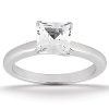 A silver engagement ring with a clear, princess-cut gemstone is displayed against a white background.
