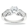 A silver engagement ring features a large round diamond center stone with smaller rectangular diamonds on each side.