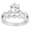 A silver engagement ring features a large round diamond at the center, flanked by smaller round diamonds in a tiered design.