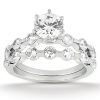 A silver engagement ring with a central large round diamond and multiple smaller diamonds set in a layered design.