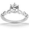 A silver engagement ring features a large central round diamond and smaller side diamonds along the band.