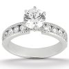 A silver engagement ring features a large round diamond at the center, surrounded by smaller diamonds set along the band.